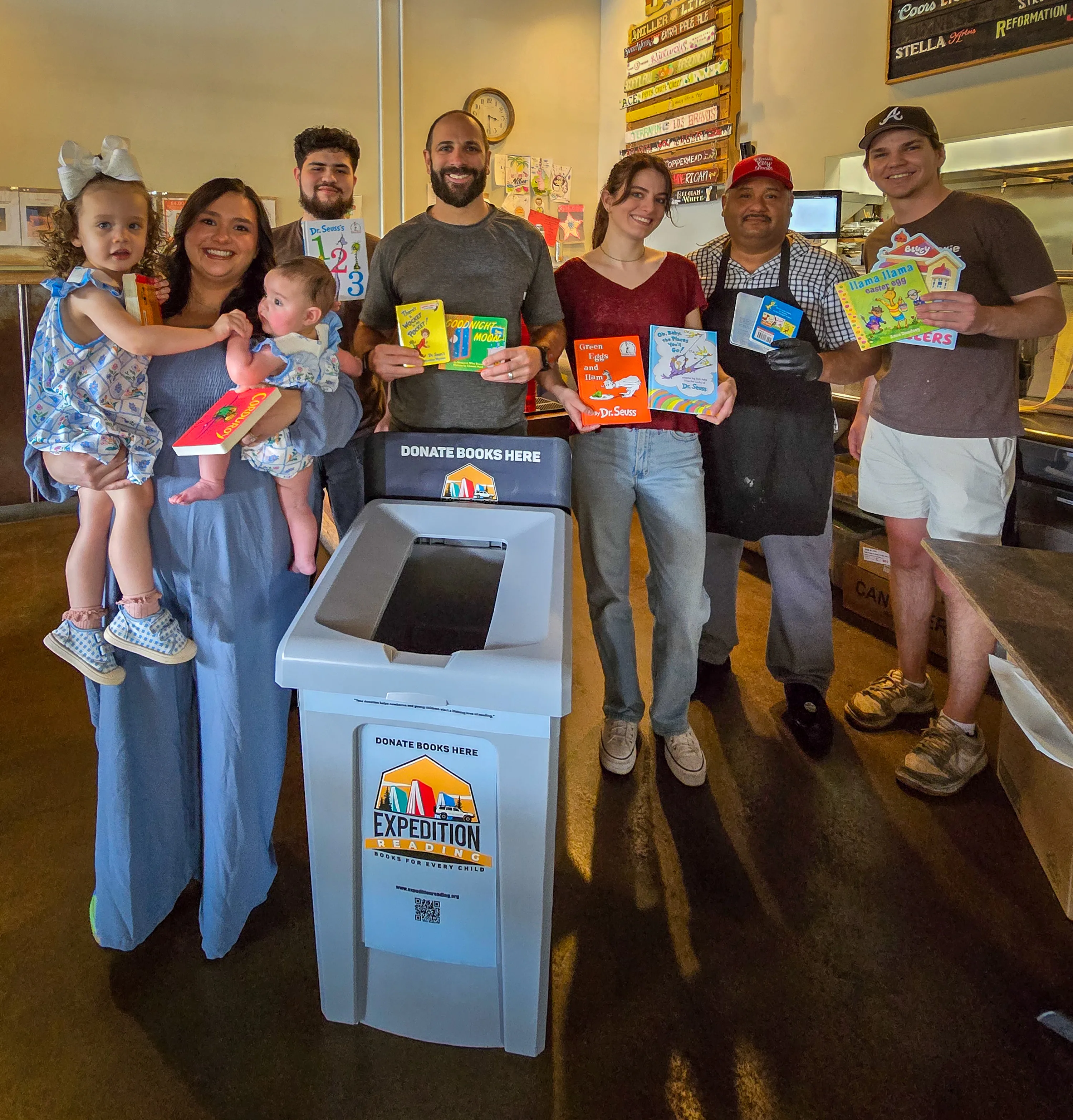 The Expedition Reading founding team and partners gathered around a donation bin at Moxie Burger Marietta